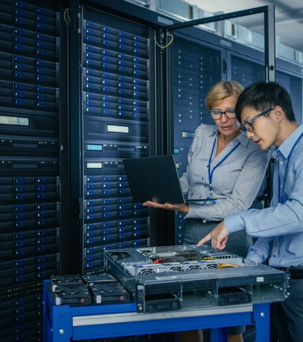 In the Modern Data Center: Engineer and IT Specialist Work with Server Racks, on a Pushcart Equipment for Installing New Hardware. Specialists Doing Maintenance and Diagnostics of the Database.